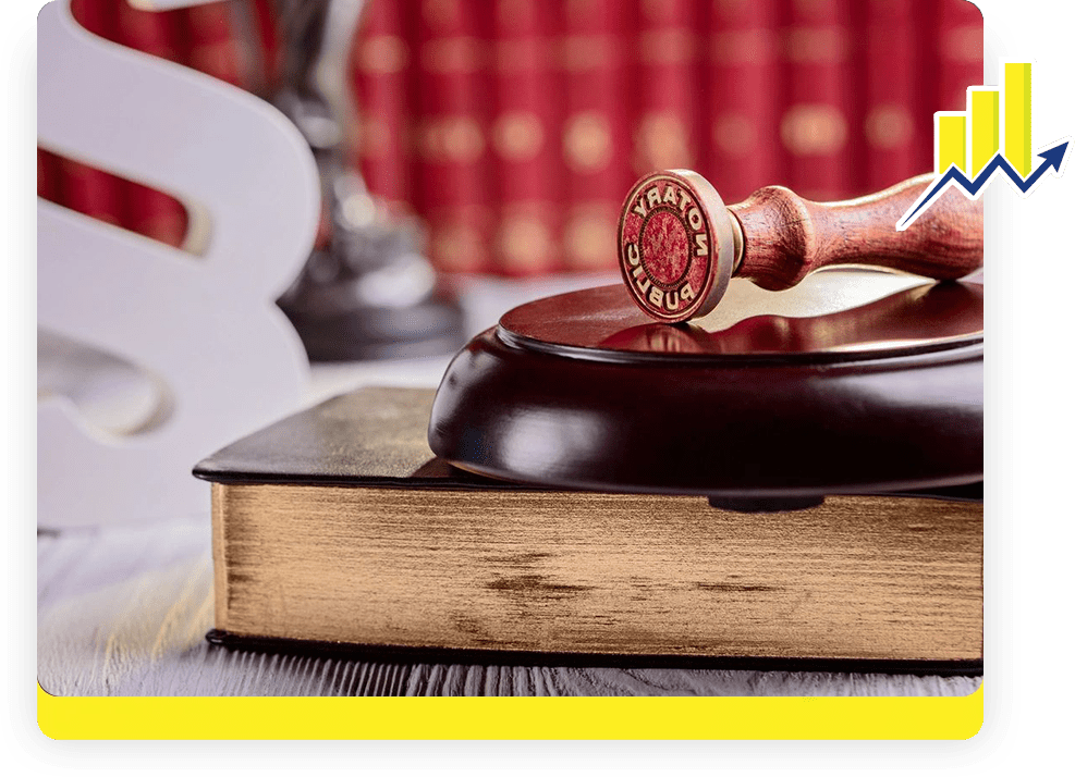 A wooden gavel sitting on top of an old book.