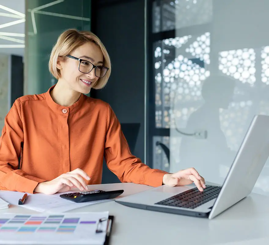 A woman sitting at her desk with a laptop.